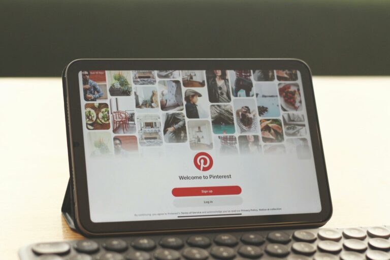 Tablet showing Pinterest homepage on a modern desk setup with a keyboard.